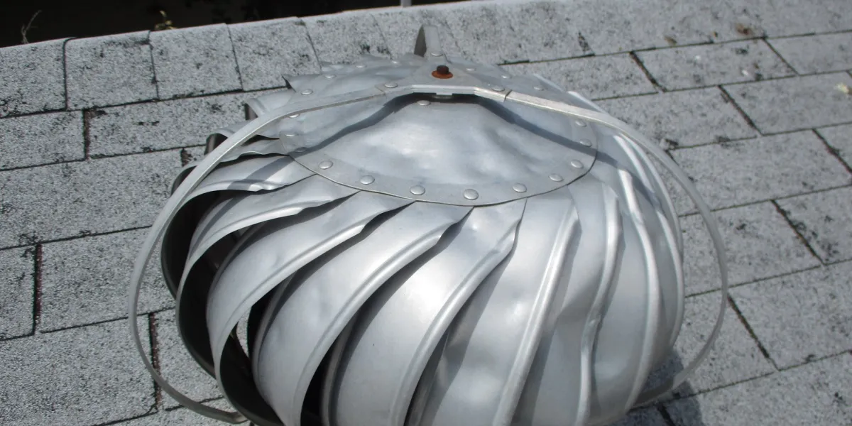 Hail-dented roof vent and surrounding shingles documented after a storm